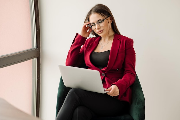 Female office worker or secretary is working with a laptop on\
the office desk portrait of sexy office worker