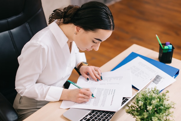 Female office worker viewing documents in workplace