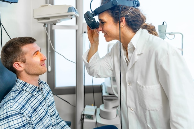 여성 안과 의사 가 환자 의 망막 을 검사 하고 있다