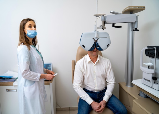 Female optometrist doing sight testing for male patient in hospital Modern equipment in ophthlmology clinic Closeup