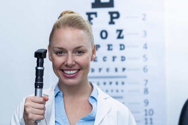 Female optometrist holding ophthalmoscope