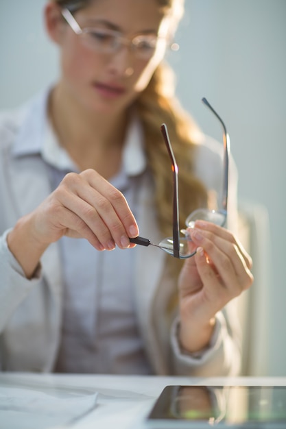 Female optometrist preparing glass frame