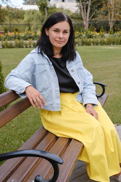 Foto donna all'aperto sulla panchina del parco donna di mezza età che guarda la telecamera