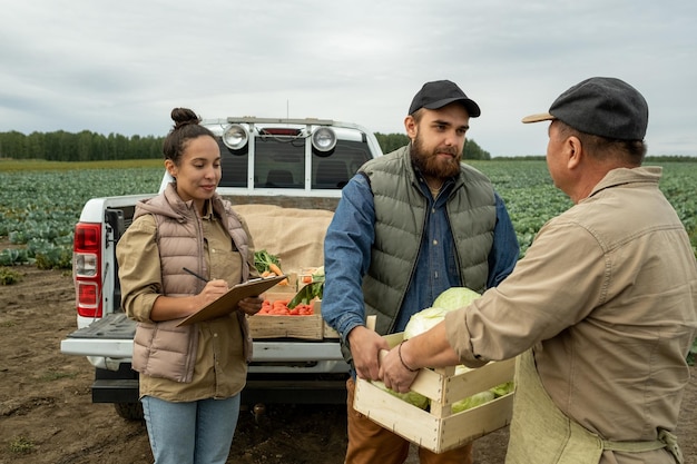 Female owner of plantation making notes about harvest in clipboard