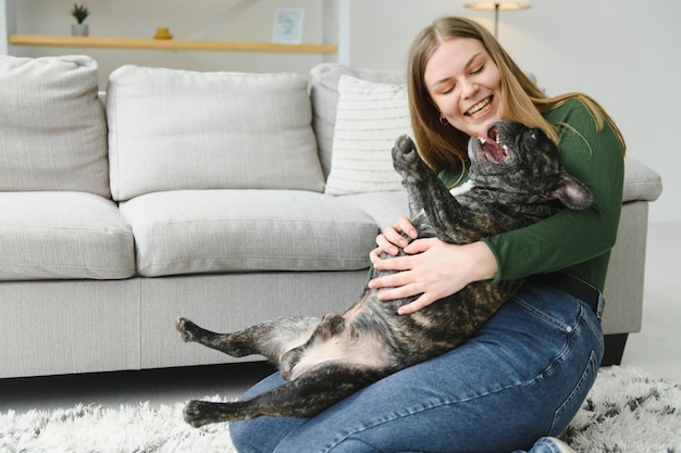 Female owner playing with joyful dog at home Playing with dog concept