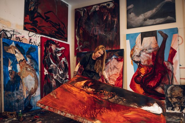 Artista pittore femminile che dipinge e crea la sua arte in uno studio creativo