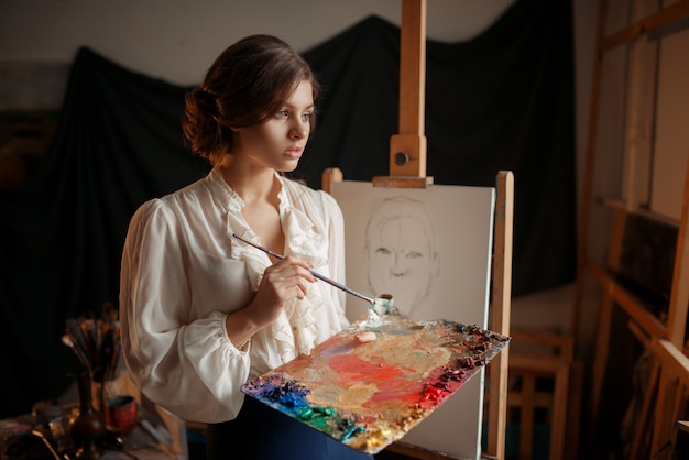 Female painter with color palette and brush