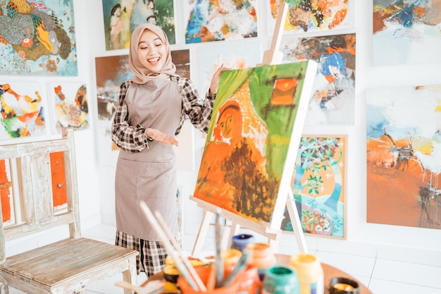 Female painting artist showing and presenting her work