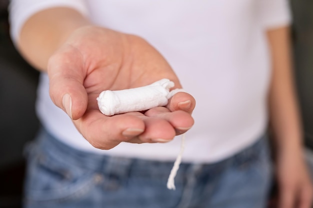 Female palm holds a menstrual tampon Concept of the period of menstruation