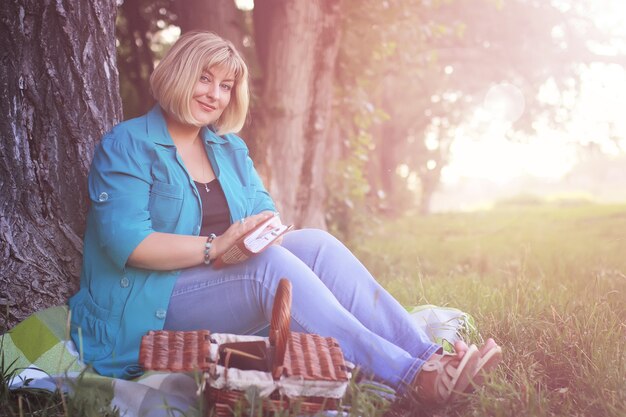 female in the park on sunset with book