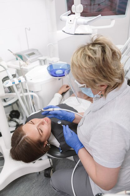 Paziente di sesso femminile che ottiene il trattamento dentale dal dentista esperto
