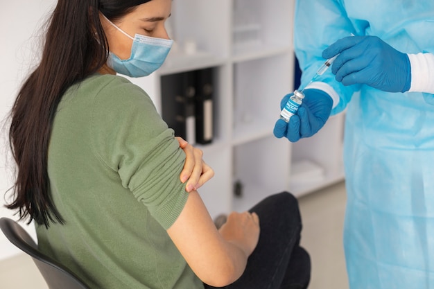 コロナウイルスの予防接種を受けている女性患者