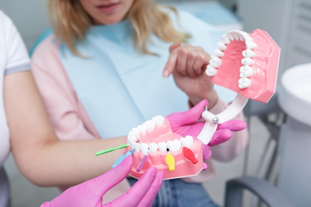 歯間ブラシを使って歯をきれいにすることを学ぶ女性患者