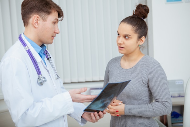 Paziente femminile che ascolta attentamente il medico mentre spiega i risultati del sondaggio a raggi x