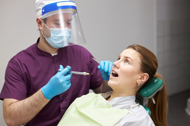 Female patient receiving injection of dental anesthesia done by dentist doctor in dentistry clinic