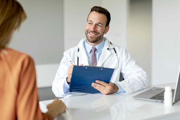 Female patient sharing talking with doctor man during meeting in office male physician holding