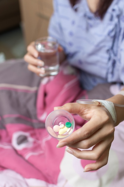 Foto paziente femminile che mostra tazza di pillole