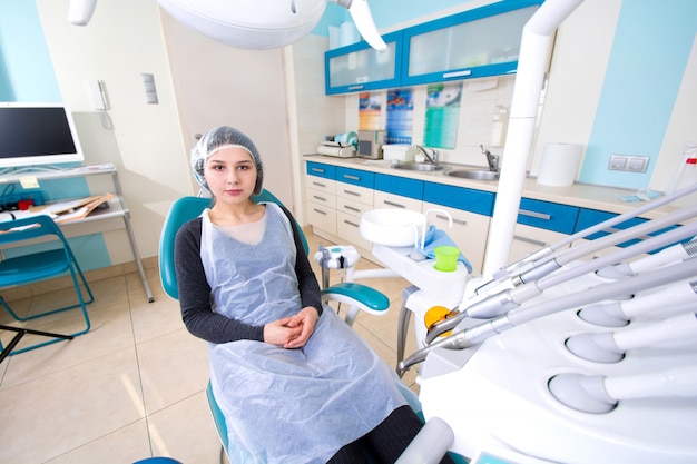 Female patient waiting for dental treatment in a dental chair.