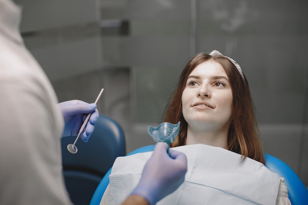 Female patient with braces has dental examination at dentist office. Stomatologist wearing blue gloves