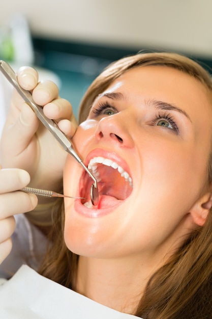 Female patient with dentist in a dental treatment, wearing gloves