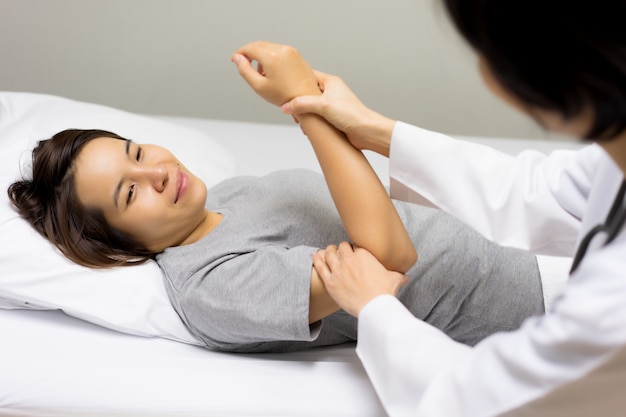 Foto le pazienti arrivano per vedere un medico per verificare il dolore al gomito