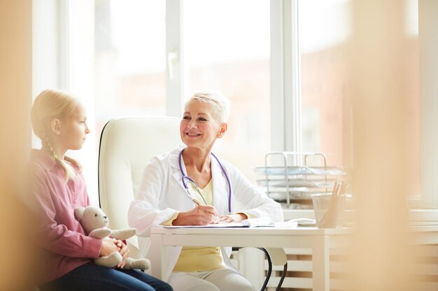 Female pediatrician asking child about complaints