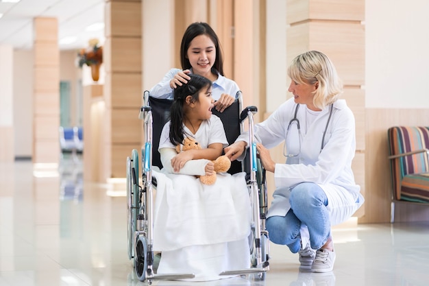 Foto medico pediatra femminile e paziente bambino su sedia a rotelle con sua madre nel centro medico sanitario