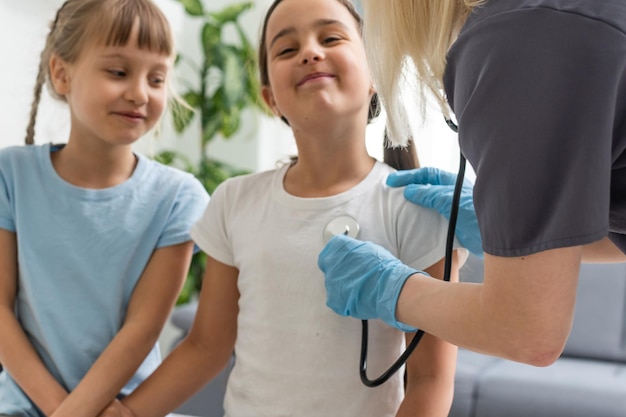 Female pediatrician doctor communicates with little girl.