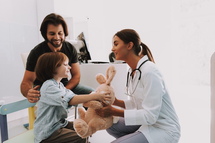 Photo female pediatrician gives bunny toy to child