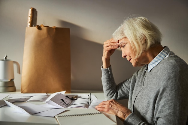 ひどい頭痛に苦しんでいる女性の年金受給者