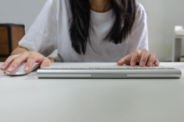 Female person holding mouse and keyboard computer technology\
internet information browsing online social media and network\
concept