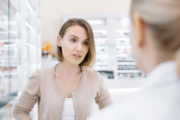 Female pharmacist helping a young woman