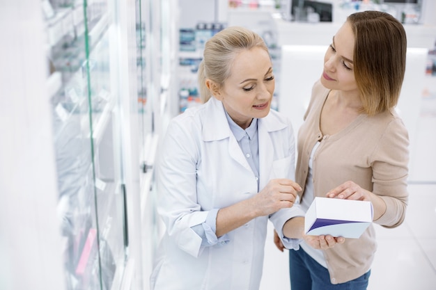 Female pharmacist helping a young woman