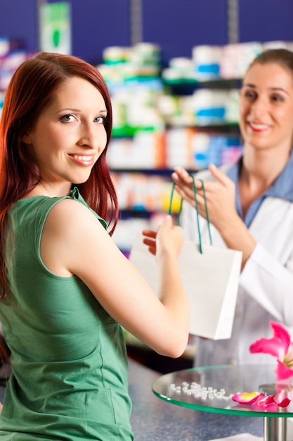 Female pharmacist in her pharmacy with a customer