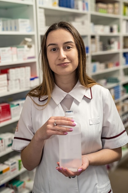 A female pharmacist holds medicine in a pharmacy