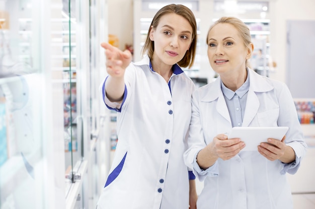 Female pharmacists checking drugs with a tablet