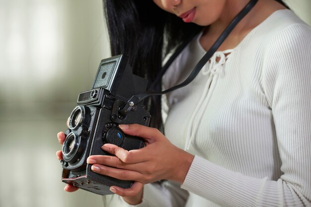 Photo female photographer adjusting vintage camera