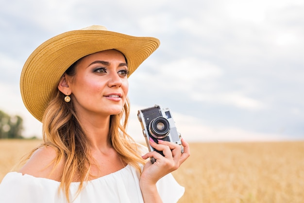 写真を撮るカメラを持つフィールドの女性写真家。