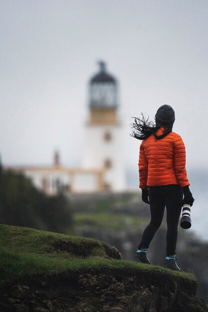 Female photographer at Neist Point Lighthouse, Isle of Skye, Scotland