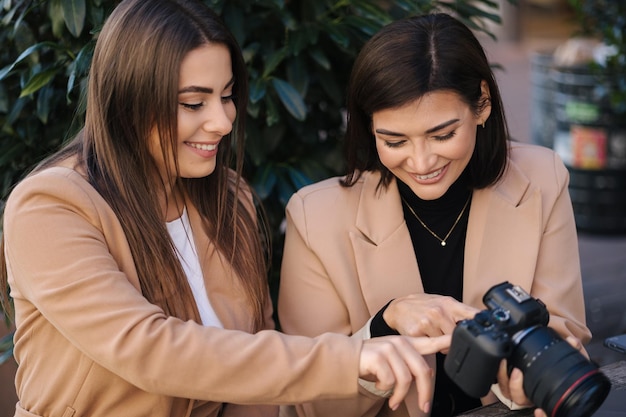 写真家がクライアントに写真を見せて カメラの写真を選び 幸せな女性が微笑み