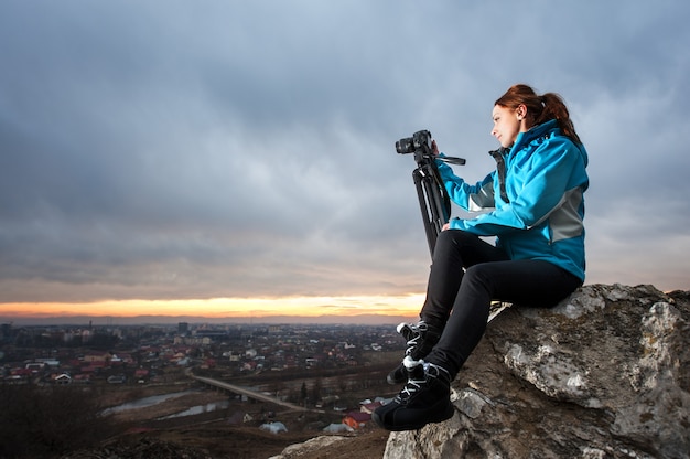 Female photographer sitting on the big rock