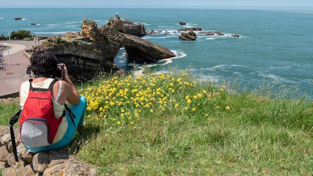 Female photographer taking a photograph of the ocean