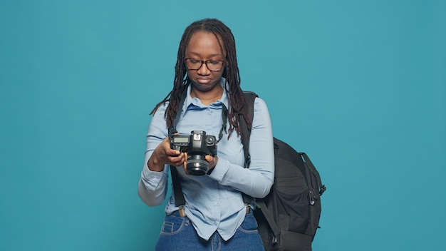 休暇中に写真を撮り、バックパックとレンズ付きカメラを運ぶ女性写真家の観光客。休暇旅行での写真撮影、観光と画像のキャプチャ、スタジオでの写真撮影。