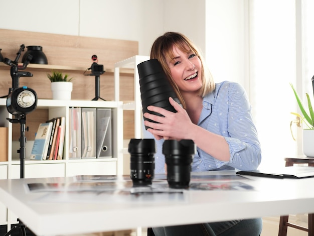 Fotografo femminile che lavora nello studio dell'ufficio e tiene un riflettore snoot