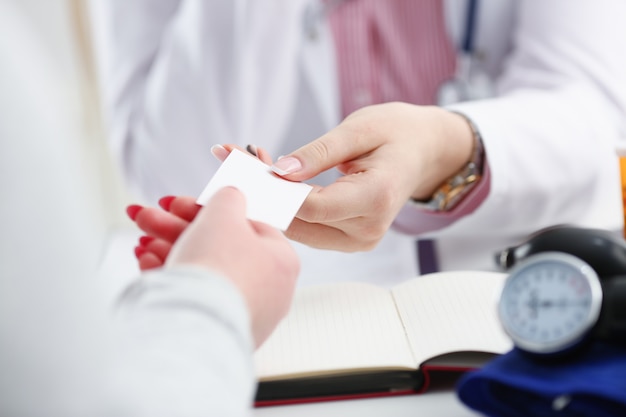 Female physician hand give white blank