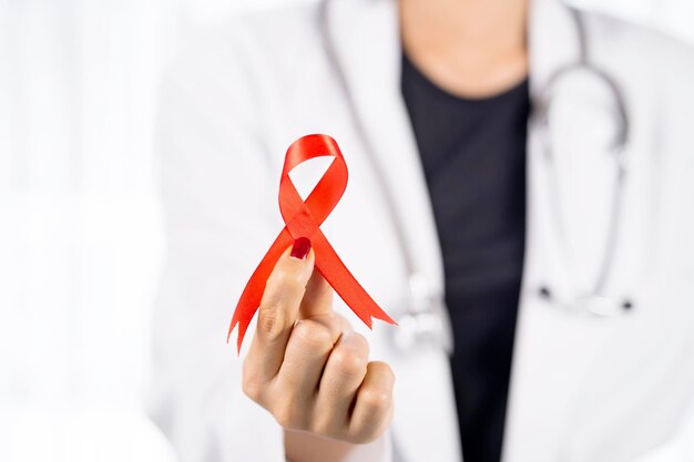 Female physician holding a red ribbon