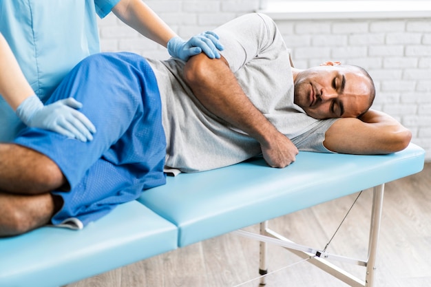 Photo female physiotherapist checking male patient