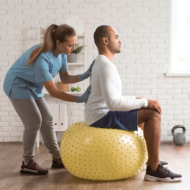 Female physiotherapist checking man's back pain