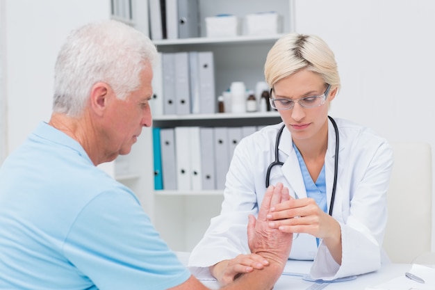 Female physiotherapist examining male patients wrist