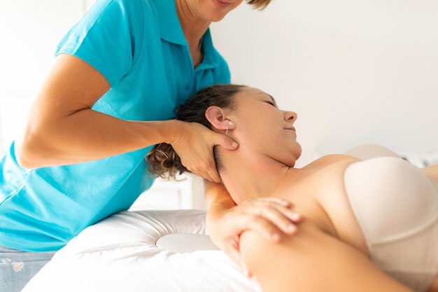 女性理学療法士が患者の首と肩のストレッチ運動を行う
